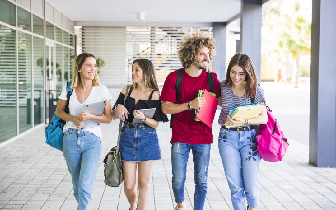 Grupo de jóvenes estudiantes caminando juntos en el campus universitario, representando el regreso a clases y la importancia de los cuidados ginecológicos y la sexualidad responsable